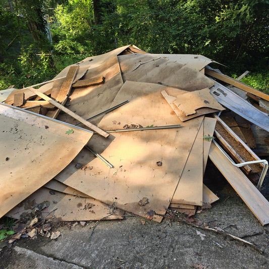 A pile of wooden boards, panels, and sheetrock from a recent construction project, awaiting removal by Wilk's Junk Service. Highlighting their expertise in efficient construction debris removal.