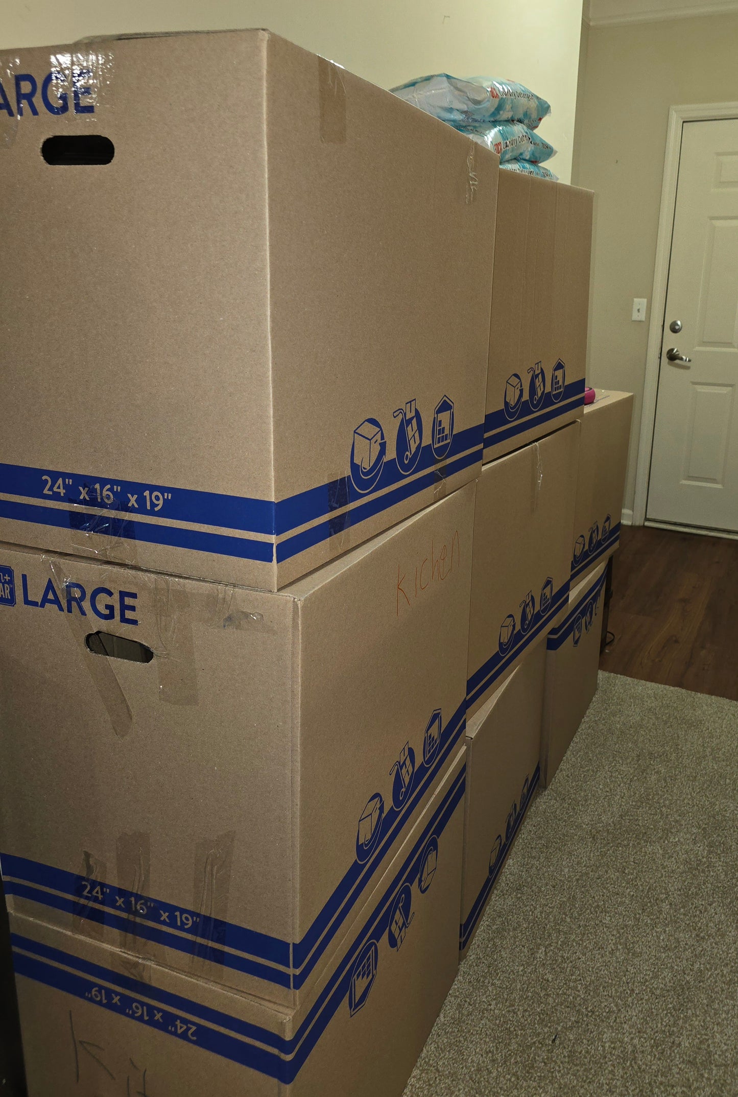 A stack of large cardboard moving boxes from Wilk's Junk Service, neatly arranged in a home setting. Showcasing their efficient moving and storage services.
