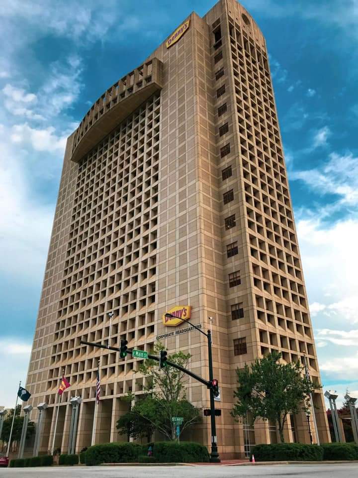 High-rise building with a unique honeycomb-like facade, numerous windows, and balconies. Trees line the street below. Photo taken before Wilk's Junk Service's commercial junk removal at Denny's.